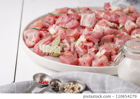 a piece of fresh raw pork meat with spices on a white wooden table. Meat with spices 110654279