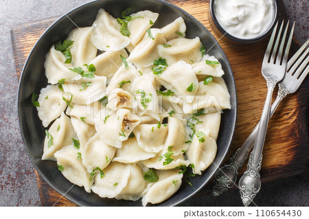 Homemade Polish dumplings small pierogi or uszka filled with mushrooms and cabbage closeup on the plate. Horizontal top view Homemade Polish dumplings small pierogi or uszka filled with mushrooms and cabbage closeup on the plate. Horizontal top view 110654430