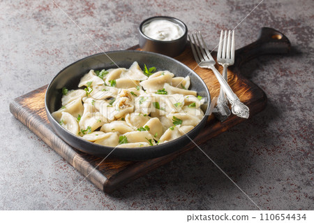 Traditional Polish Christmas Eve mushroom dumplings uszka served with sour cream closeup on the plate. Horizontal Traditional Polish Christmas Eve mushroom dumplings uszka served with sour cream closeup on the plate. Horizontal 110654434