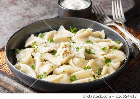 Polish Little Ears Dumplings Uszka filled with mushrooms and cabbage closeup on the plate. Horizontal Polish Little Ears Dumplings Uszka filled with mushrooms and cabbage closeup on the plate. Horizontal 110654438