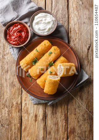 Krokiety Polish style croquettes filled with beef closeup on the plate. Vertical top view 110654487