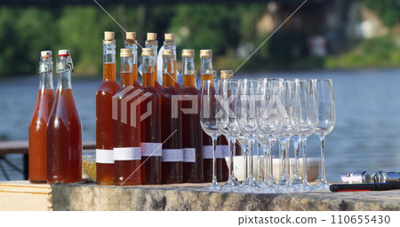 Fresh fruit cider and glasses at stall at farmers market Fresh fruit cider and glasses at stall at farmers market 110655430