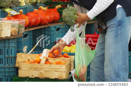 A female customer buying fresh fruit and vegetables at the outdoor market A female customer buying fresh fruit and vegetables at the outdoor market 110655483