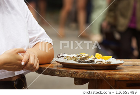 Young woman with a tray of oysters at a farmers market 110655489