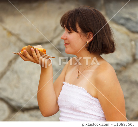 I married my favourite pastry and we are so happy together. Young woman holding pastry in hand. 110655503