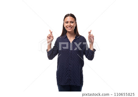young cheerful cute caucasian brunette lady dressed in a dark blue blouse crossed her fingers young cheerful cute caucasian brunette lady dressed in a dark blue blouse crossed her fingers 110655825