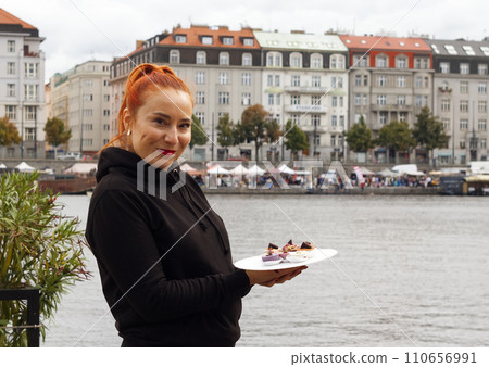 Pretty young woman, model holding plate with mini desserts. Pretty young woman, model holding plate with mini desserts. 110656991