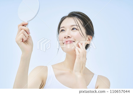 一位女士用手鏡檢查自己的皮膚狀況 一位女士用手鏡檢查自己的皮膚狀況 110657044