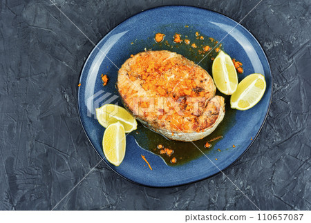 Salmon or trout steak in orange marinade. 110657087