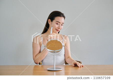 一名30多歲的女士用電動刮鬍刀刮臉 一名30多歲的女士用電動刮鬍刀刮臉 110657109
