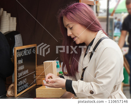 Attractive young woman buying coffee at farmers stall in Prague. 110657146
