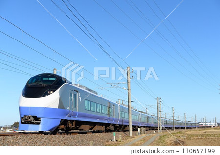 A Joban Line limited express train in revival blue colours running around a curve 110657199