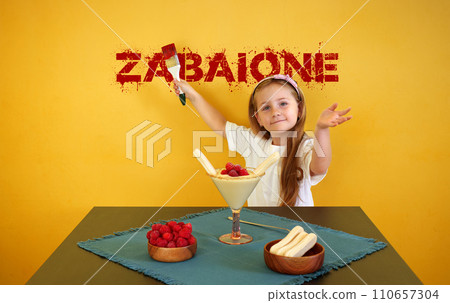 Cute baby girl with dessert and zabaione inscription. 110657304