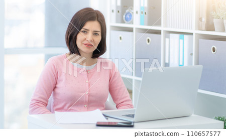 Smiling business woman sitting in beautiful office Smiling business woman sitting in beautiful office 110657577