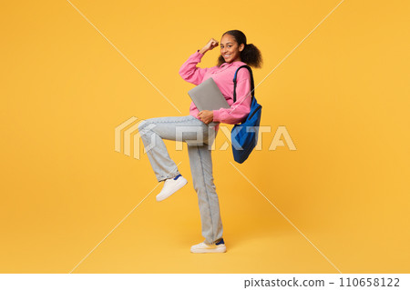black teen student lady with laptop gesturing yes, yellow background black teen student lady with laptop gesturing yes, yellow background 110658122
