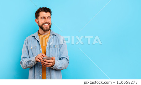 man texting on mobile phone near free space, blue background man texting on mobile phone near free space, blue background 110658275
