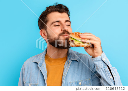 Portrait Of Cheerful Guy Posing With Burger Eating Big Sandwich 110658312