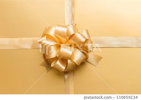 Top view of gold ribbon rolled and yellow bow isolated on colored background. Flat lay with copy space 110659134