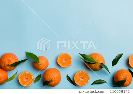 Many fresh ripe mandarin with green leaves on colored background, top view, space for text 110659141