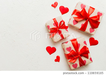 Top view photo of valentine day decorations gift box with red ribbon bow on colored background. Holiday gift boxes with top view 110659185
