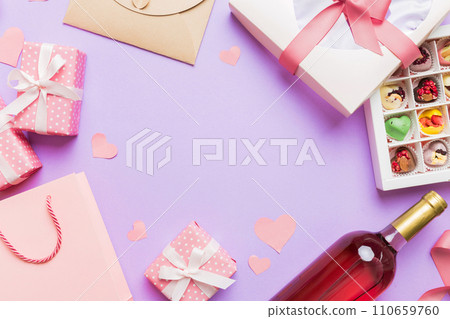top view photo of st valentine day decor shopping, bag, wine, bottle, envelope, gift, box, candy and red heart on colored background with empty space. Frame background top view photo of st valentine day decor shopping, bag, wine, bottle, envelope, gift, box, candy and red heart on colored background with empty space. Frame background 110659760