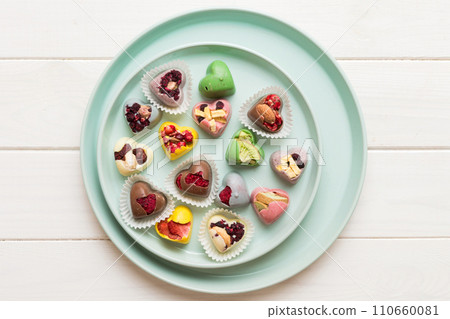 Plate with different chocolate on colored background. Assortment of fine chocolates top view vith copy space Health and obesity concept 110660081