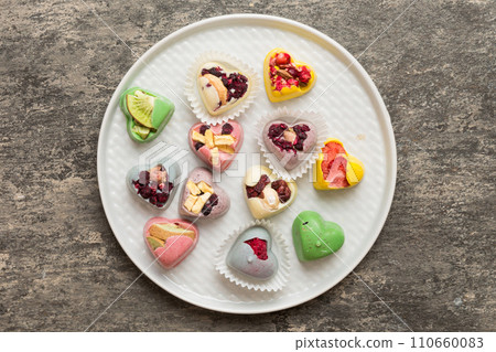 Plate with different chocolate on colored background. Assortment of fine chocolates top view vith copy space Health and obesity concept 110660083