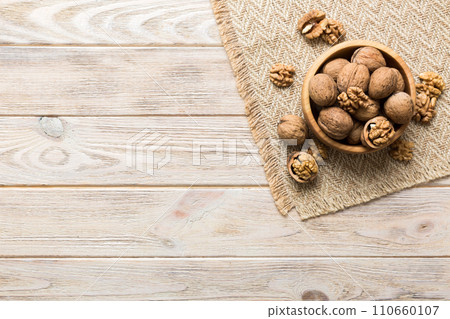 Fresh healthy walnuts in bowl on colored table background. Top view Healthy eating bertholletia concept. Super foods Fresh healthy walnuts in bowl on colored table background. Top view Healthy eating bertholletia concept. Super foods 110660107