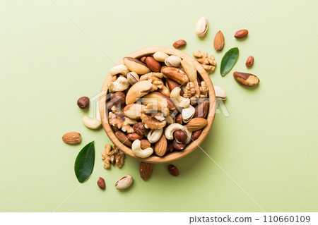 mixed nuts in bowl. Mix of various nuts on colored background. pistachios, cashews, walnuts, hazelnuts, peanuts and brazil nuts mixed nuts in bowl. Mix of various nuts on colored background. pistachios, cashews, walnuts, hazelnuts, peanuts and brazil nuts 110660109