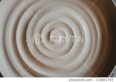 A beautiful spiral, a helical line on a clay surface. Pottery, clay texture decorated with a spiral notch. Abstract clay background Macro, top view A beautiful spiral, a helical line on a clay surface. Pottery, clay texture decorated with a spiral notch. Abstract clay background Macro, top view 110661783