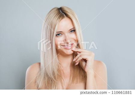 Cheerful smiling joyfully female model with fair hair looking at camera, being happy. Studio shot Cheerful smiling joyfully female model with fair hair looking at camera, being happy. Studio shot 110661881