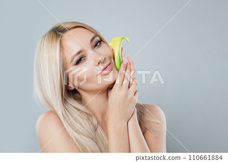 Cheerful healthy woman with blonde hairstyle, clean fresh skin holding summer yellow flower 110661884