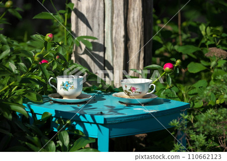 White China Teacups on Blue Table in Garden Double as Garden Art and Bird Baths 110662123