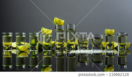 Tequila shots with lime slices and salt on a grey background. 110662128