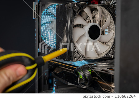 Cleaning the computer video card from dust with a brush and air. Computer fans in dust Cleaning the computer video card from dust with a brush and air. Computer fans in dust 110662264