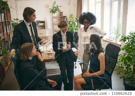 Group of happy young Asian college students studying, shares information with their classmates brainstorming on their school project together. 110662628