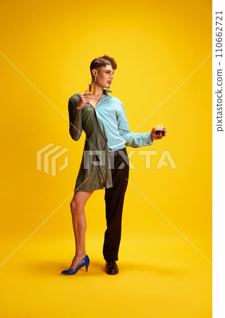 Mode half-dressed in dress and smart casual costume, holds glasses of whiskey and champagne, breaking gender stereotypes and encouraging self-expression. 110662721
