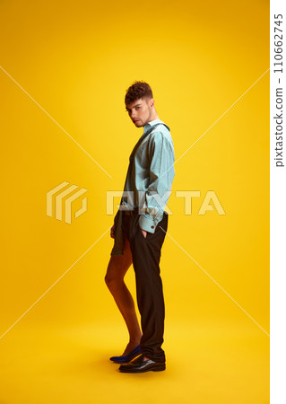 Full length portrait of young man with male and female halved appearance showing gender fluidity and progressive fashion choices 110662745