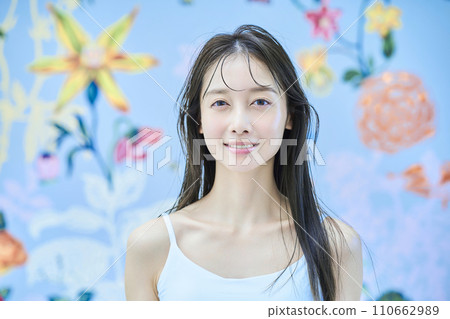 A woman standing in front of brightly patterned wallpaper A woman standing in front of brightly patterned wallpaper 110662989