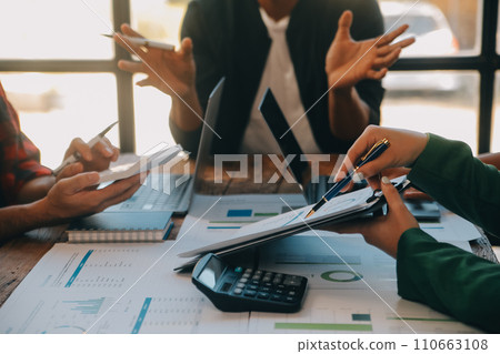 Co working conference, Business team meeting present, investor colleagues discussing new plan financial graph data on office table with laptop and digital tablet, Finance, accounting, investment. Co working conference, Business team meeting present, investor colleagues discussing new plan financial graph data on office table with laptop and digital tablet, Finance, accounting, investment. 110663108