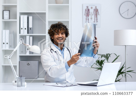 A professional Hindu doctor examines an X-ray in a well-equipped medical office, portraying healthcare expertise. A professional Hindu doctor examines an X-ray in a well-equipped medical office, portraying healthcare expertise. 110663377
