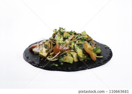 fried assorted vegetables with meat in a flat plate on a white background, side view fried assorted vegetables with meat in a flat plate on a white background, side view 110663681