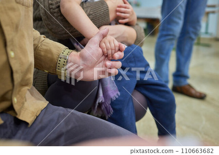 Newborn baby baptism in Holy water. baby holding mother's hands. Infant bathe in water. Baptism in the font. Sacrament of baptism 110663682