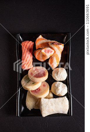 sliced ingredients in a flat black plate on a white background top view 110663691