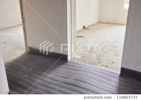 Sheet of expanded polystyrene on the concrete floor for house thermal insulation during constructions Sheet of expanded polystyrene on the concrete floor for house thermal insulation during constructions 110663735