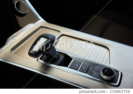 Selector automatic transmission with leather in the interior of a modern expensive car. The background is blurred. Black and brown leather car. Selector automatic transmission with leather in the interior of a modern expensive car. The background is blurred. Black and brown leather car. 110663759