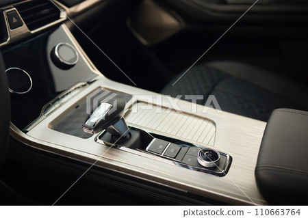 Selector automatic transmission with leather in the interior of a modern expensive car. The background is blurred. Black and brown leather car. Selector automatic transmission with leather in the interior of a modern expensive car. The background is blurred. Black and brown leather car. 110663764