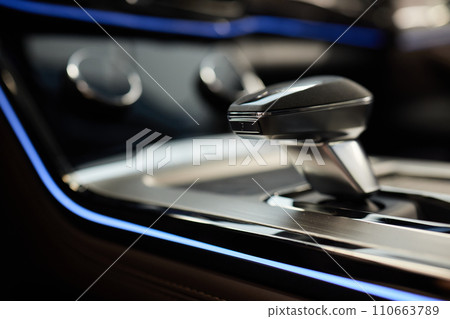 Selector automatic transmission with leather in the interior of a modern expensive car. The background is blurred. Black and brown leather car. Selector automatic transmission with leather in the interior of a modern expensive car. The background is blurred. Black and brown leather car. 110663789