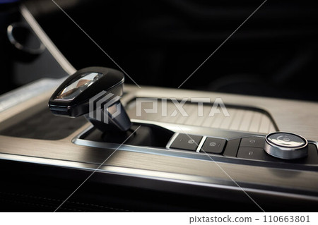 Selector automatic transmission with leather in the interior of a modern expensive car. The background is blurred. Black and brown leather car. Selector automatic transmission with leather in the interior of a modern expensive car. The background is blurred. Black and brown leather car. 110663801