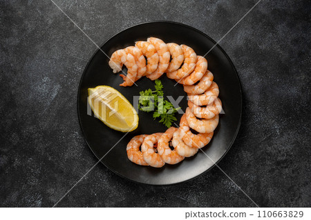 Cooked shrimps in a black plate, over dark background 110663829